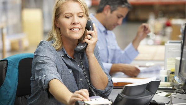 Businesswoman Working At Desk In Warehouse