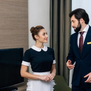 young hotel service staff talking at suite