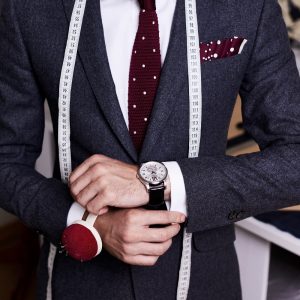 Mid section portrait of handsome bearded tailor wearing fashionable suit and jacket posing in atelier studio