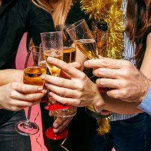 Many young women and men drinking at christmas party on white studio background